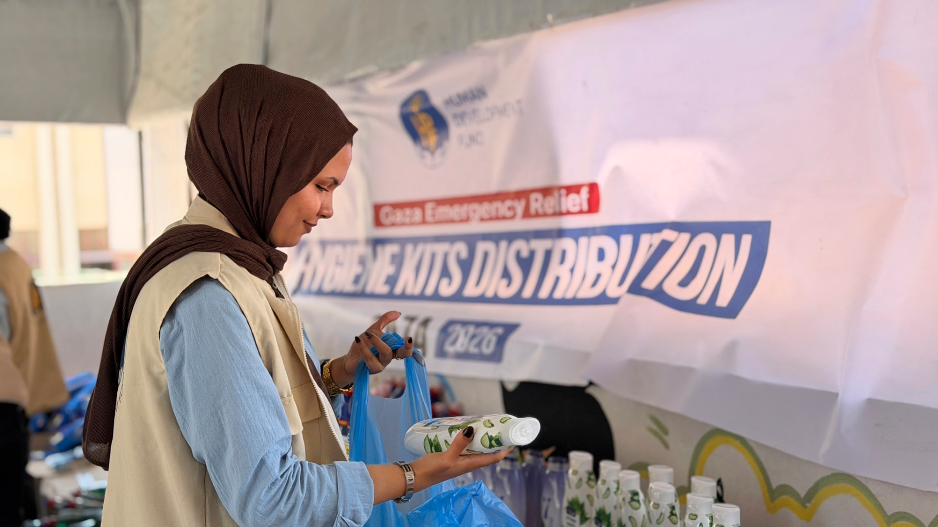 HDF field worker distributing hygiene and menstrual kits to women in Gaza under an HDF Gaza Emergency Relief banner