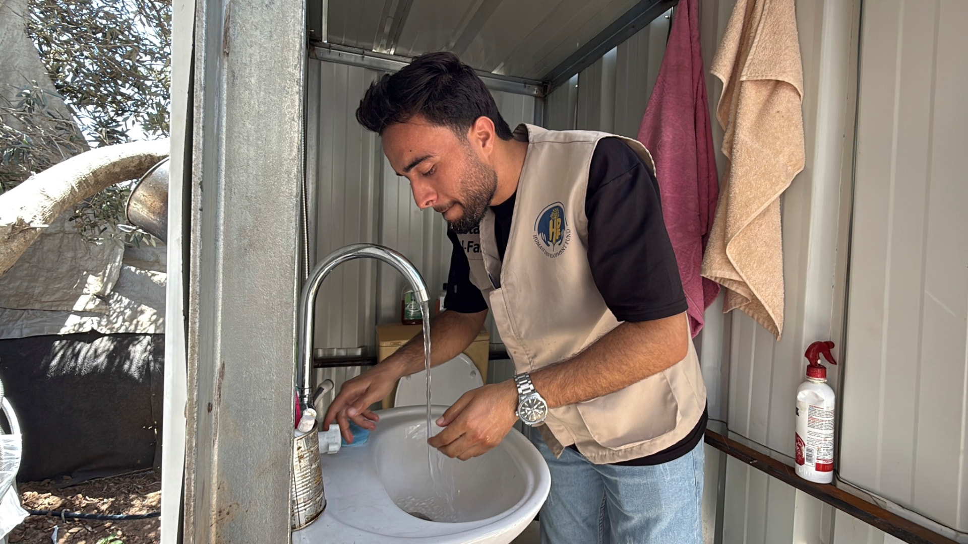 HDF field worker washing his hands at a sink inside an HDF sanitation unit in Gaza